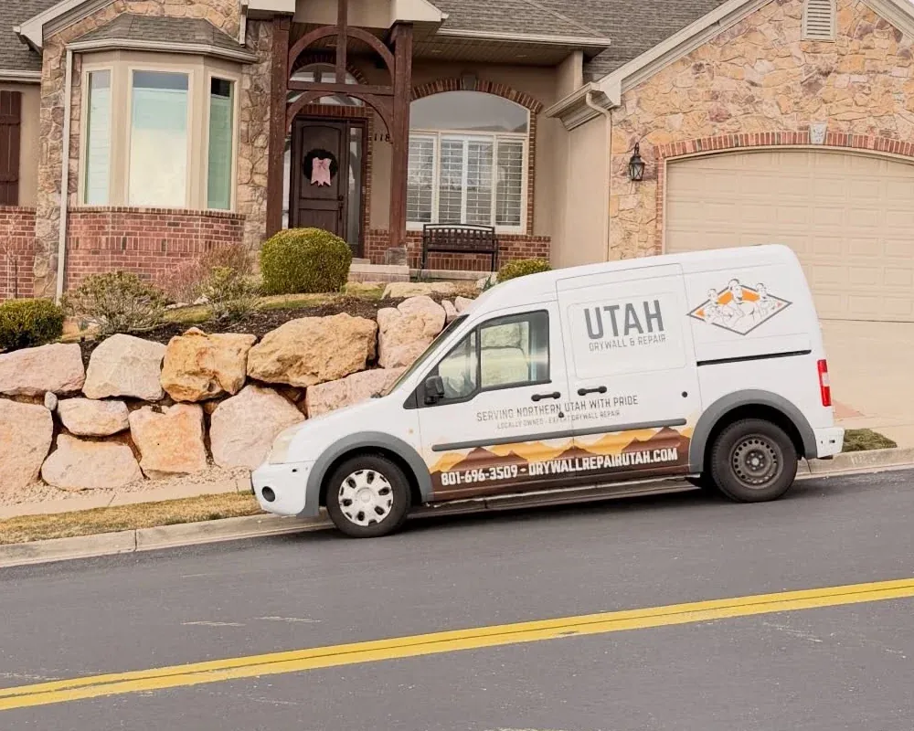 Branded Utah Drywall & Repair service van parked outside a residential home